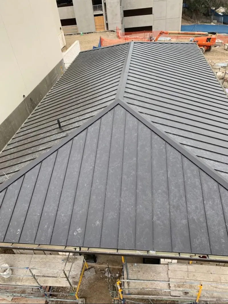 Commercial metal roof construction with crane equipment in Inverness